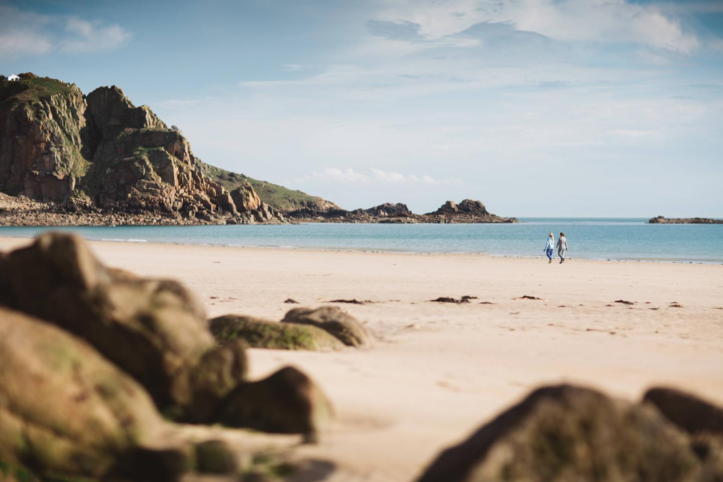 Couple walking along St.Brelade’s Bay